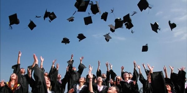 Students after graduation, flying away their graduation hats.