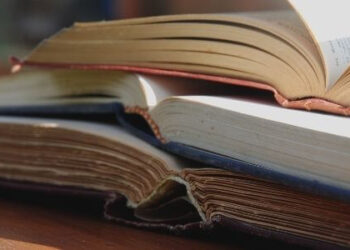 UPSC Mains Syllabus PDF. The featured image of the article is open books kept on top of each other.